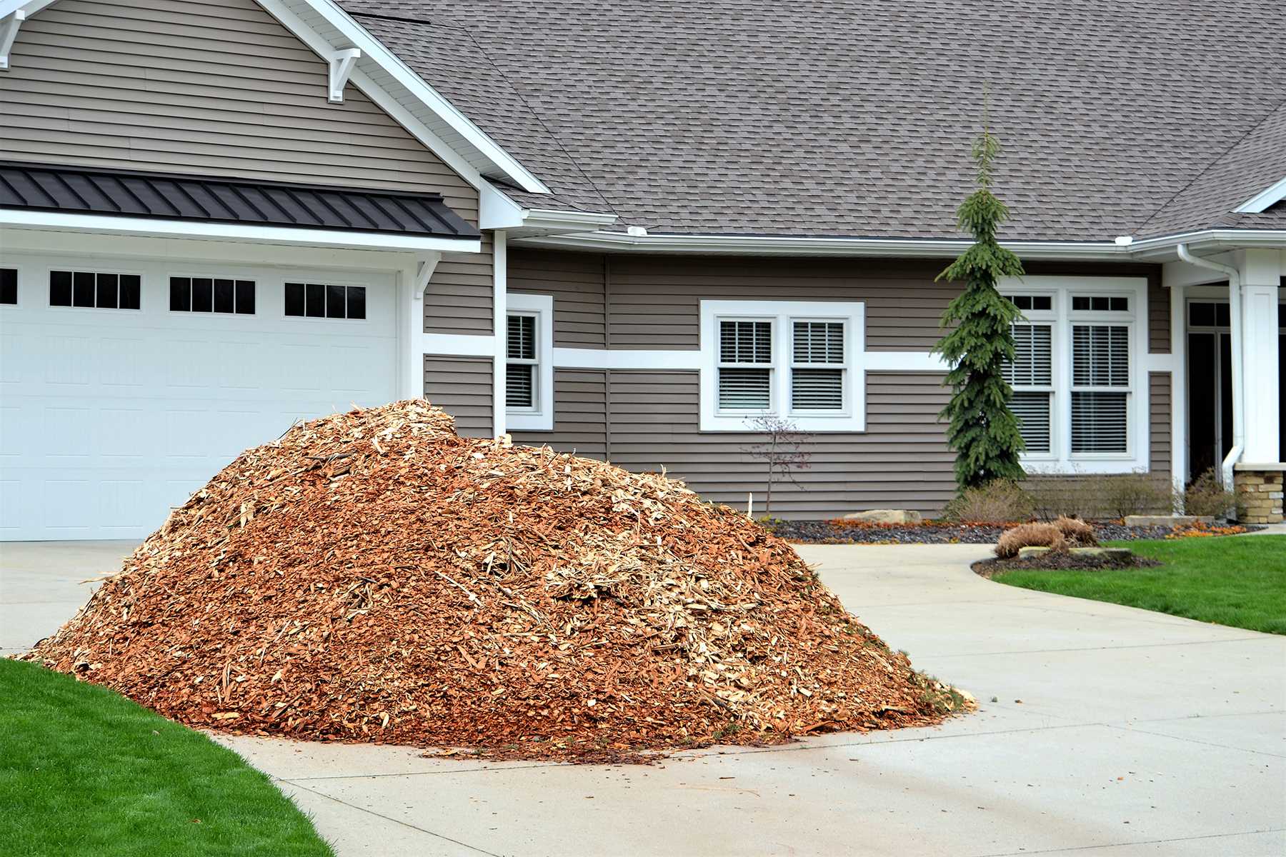 Green Garden Township Mulch Program graphic - photo of brown house with pile of mulch on cement driveway